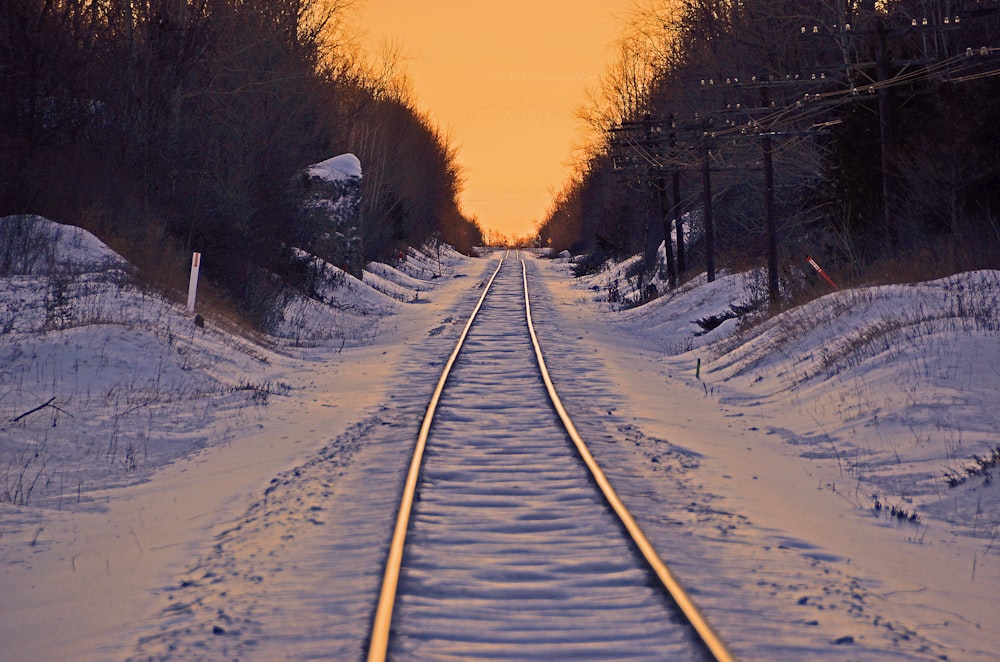 train rail covered with snow during sunset