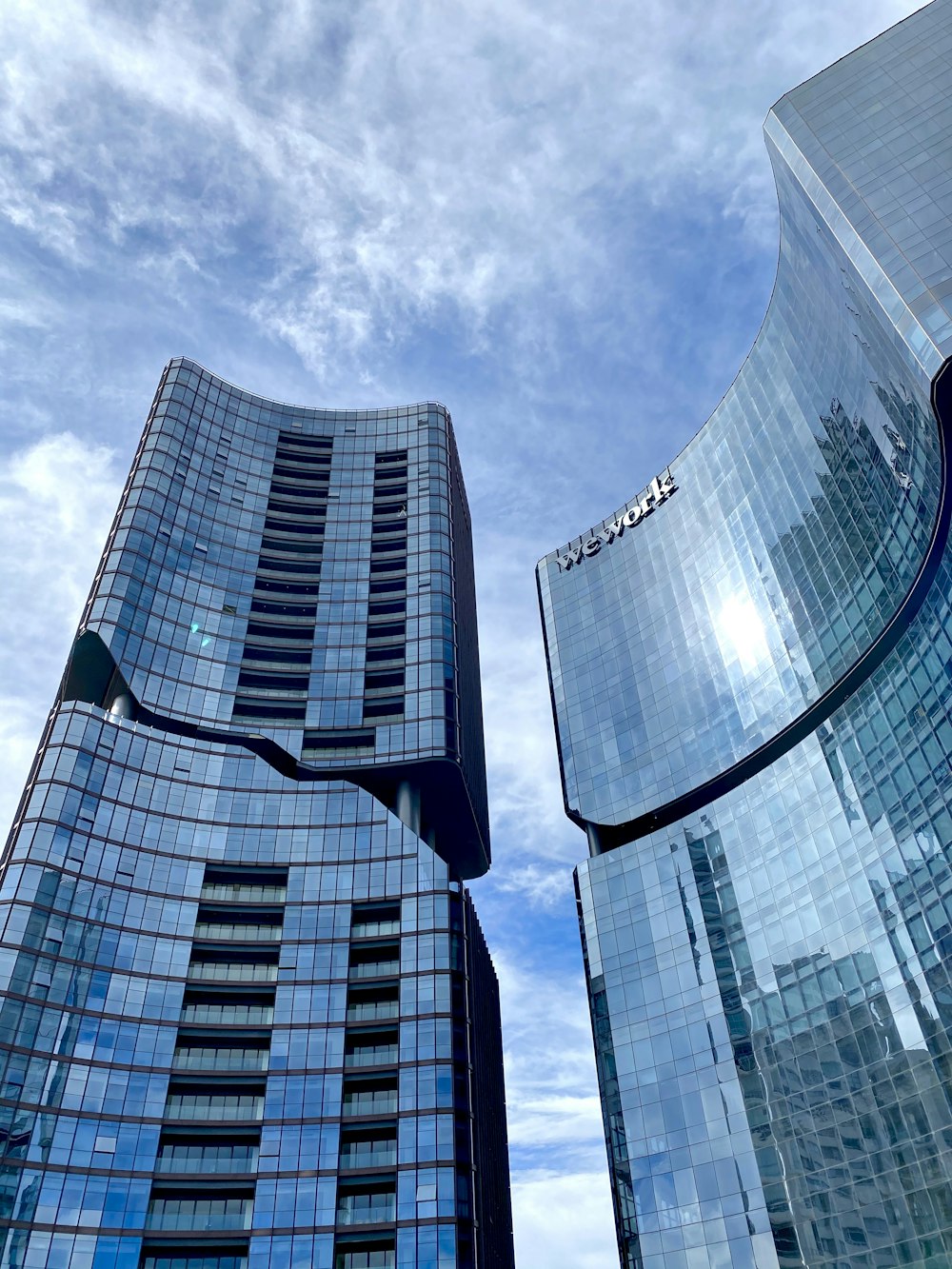 worms eye view of glass building under cloudy sky during daytime