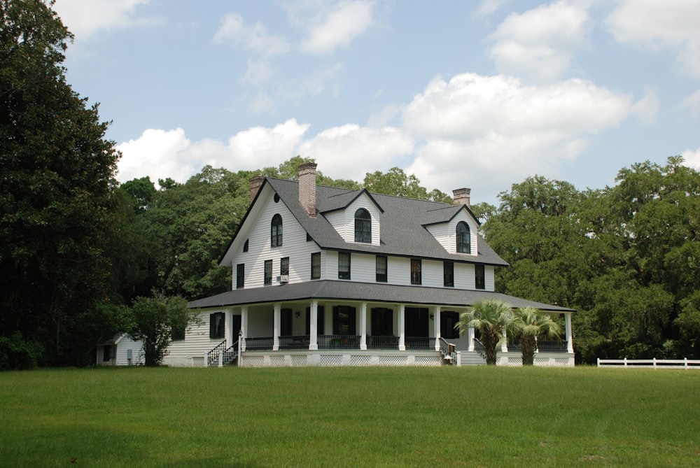 white and black house near green grass field during daytime