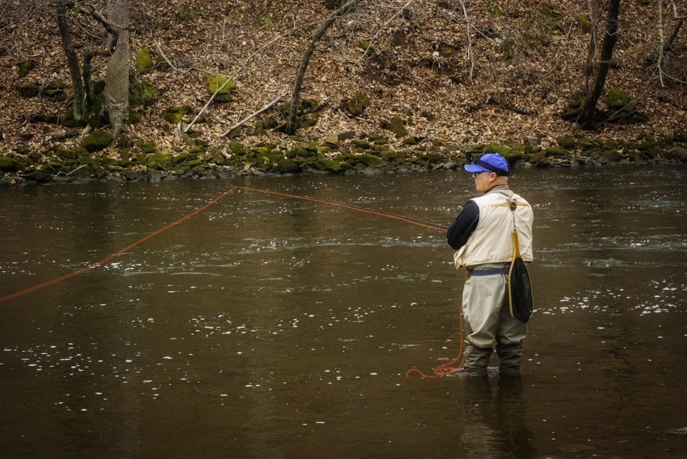 woman in brown jacket and brown skirt fishing on river during daytime