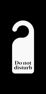 A door hanger hanging on a front door, showcasing a bright and eye-catching design