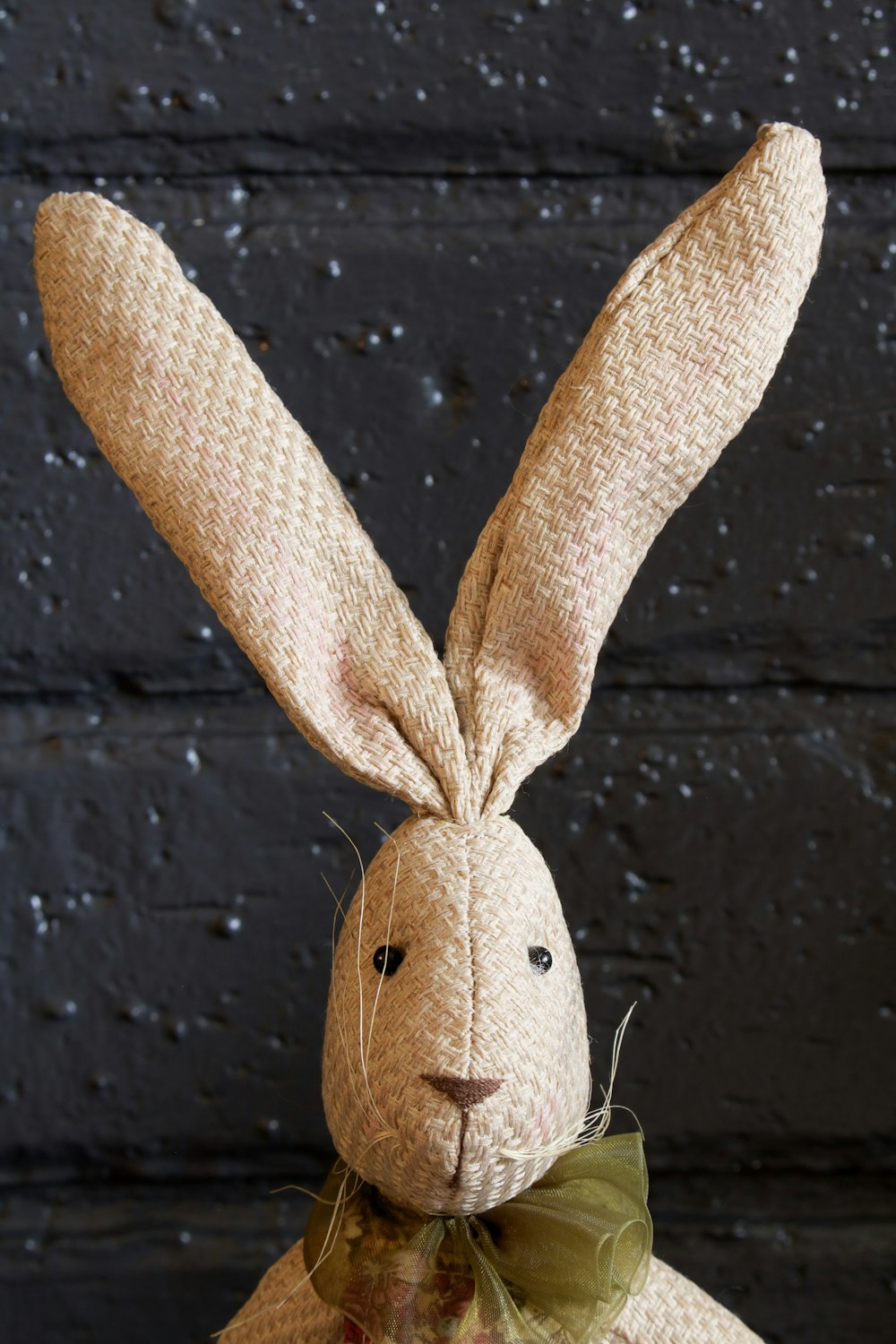 brown rabbit plush toy on black wooden surface