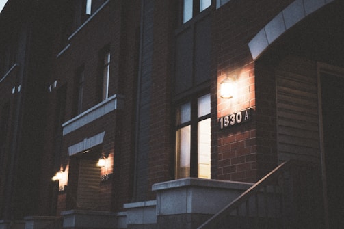 A renovated NYC townhouse with modern condo units and warm lighting at dusk.