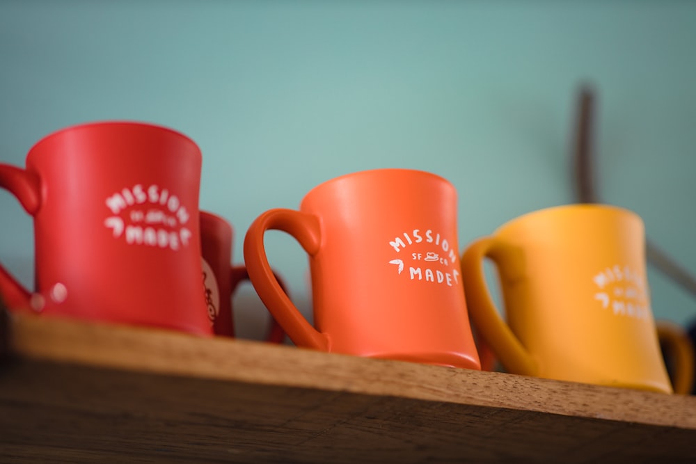 red and white ceramic mug on brown wooden table