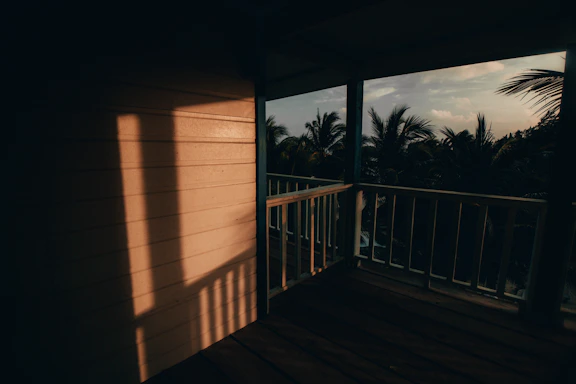 A warm, welcoming front porch of a cozy home with a gentle sunset in the background.