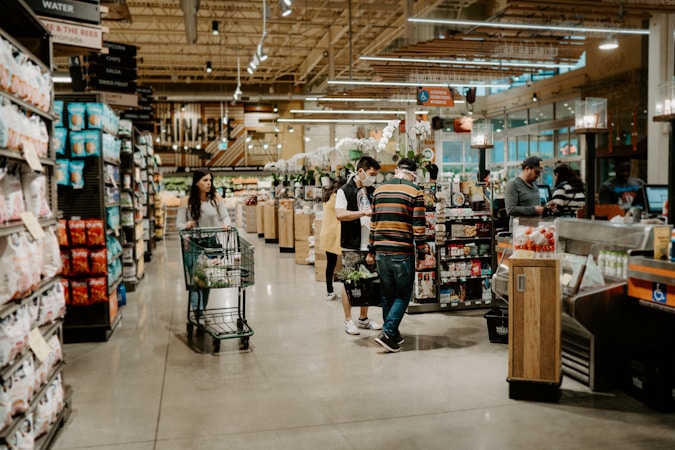 Shoppers walking through a market with fresh food on display, illustrating the grocery budget relief Clark County parents get from free CCSD school meals