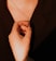 A close-up of hands gently holding a wooden cross with soft natural light.