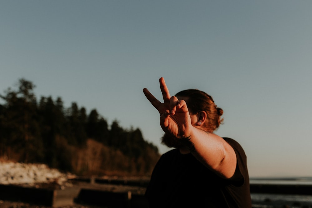 woman in black tank top raising her right hand