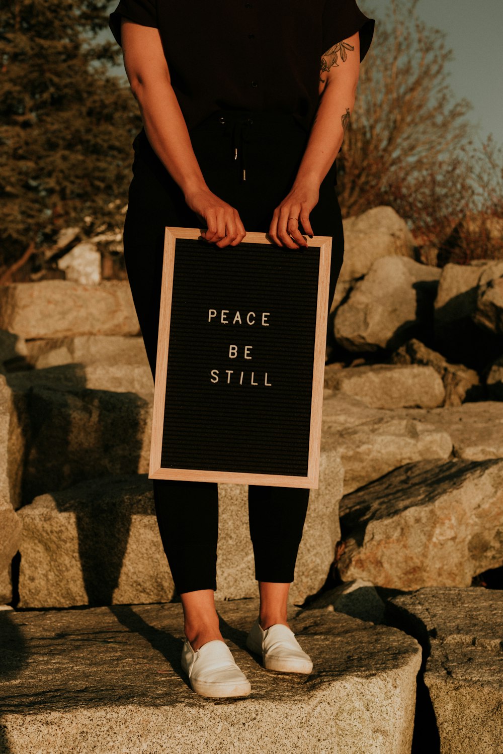 woman in black tank top and black leggings standing on gray rock