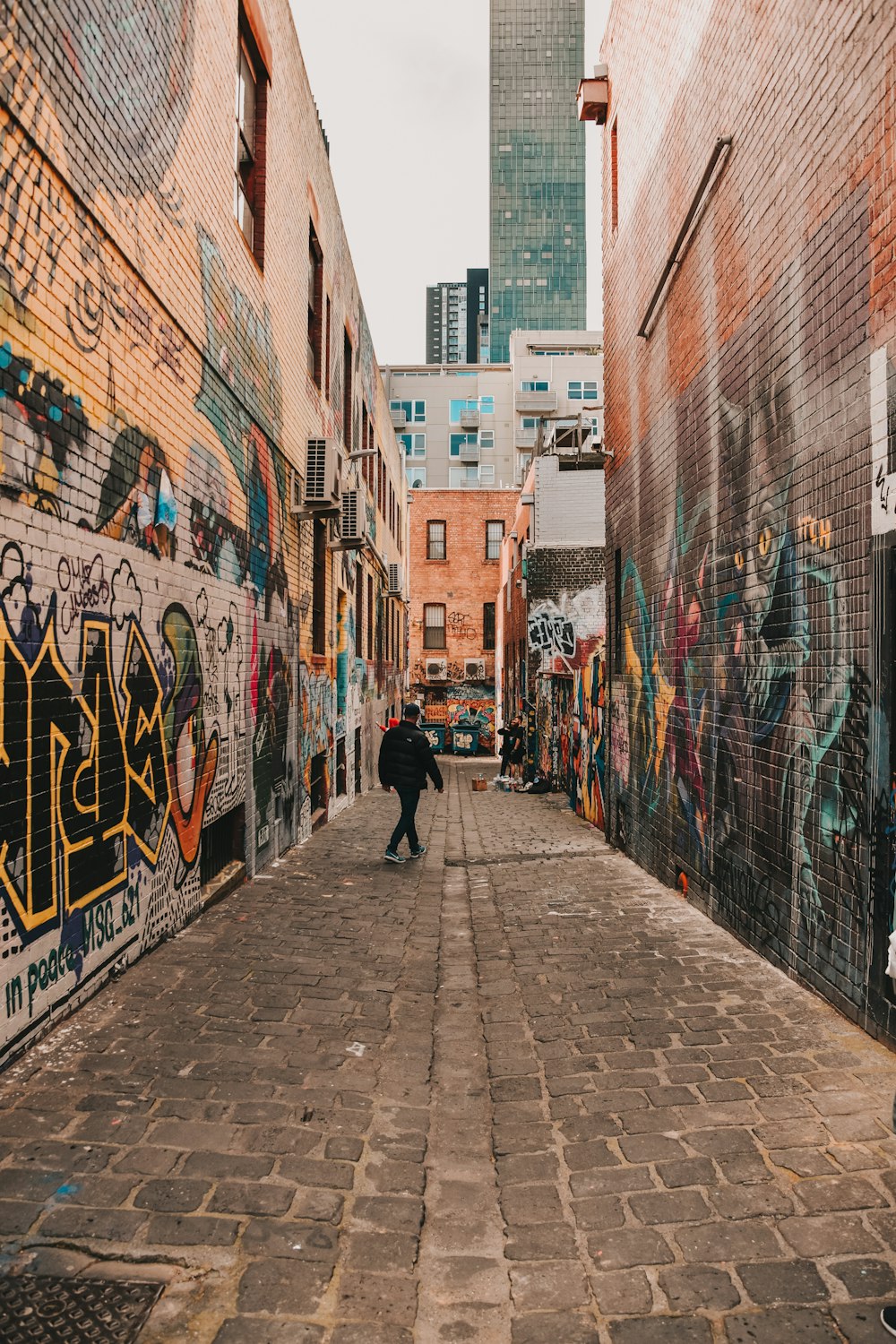 man in black jacket walking on sidewalk during daytime