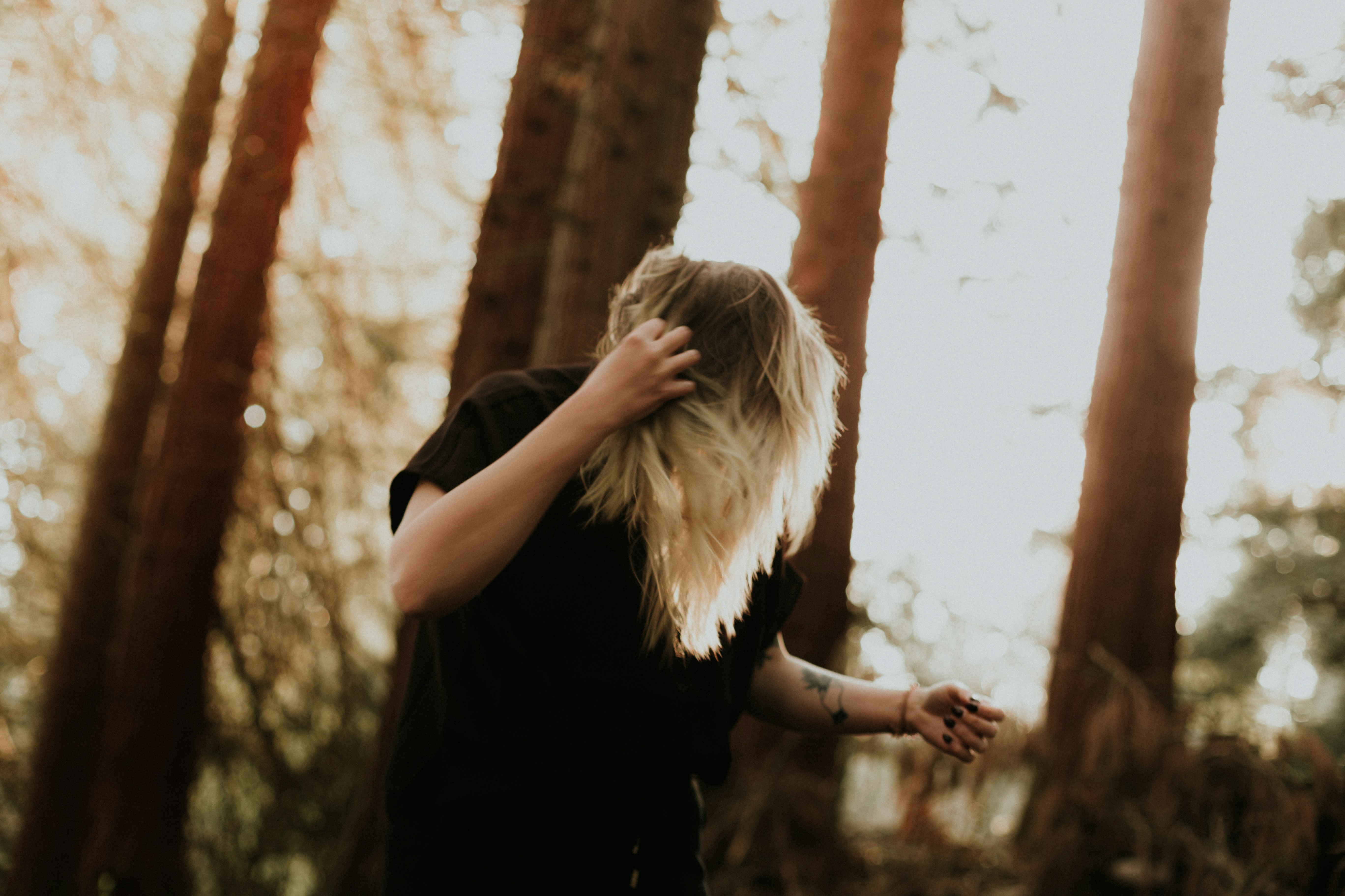 woman in black shirt standing near white wall during daytime