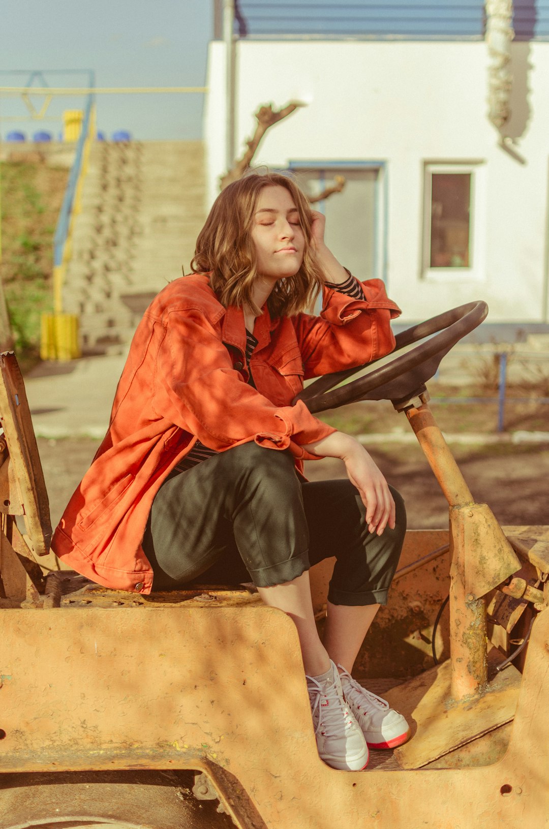 woman in red long sleeve shirt sitting on brown wooden chair