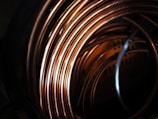 Copper coils shining with a rich reddish hue in an industrial setting.