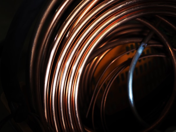 Close-up of shiny pure copper sheets stacked neatly in a warehouse.