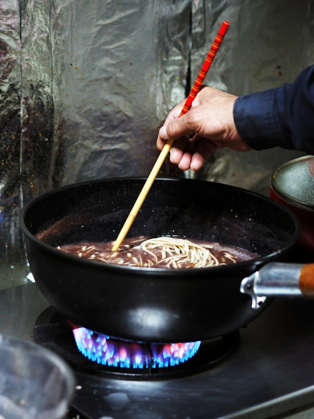 person holding brown wooden chopsticks