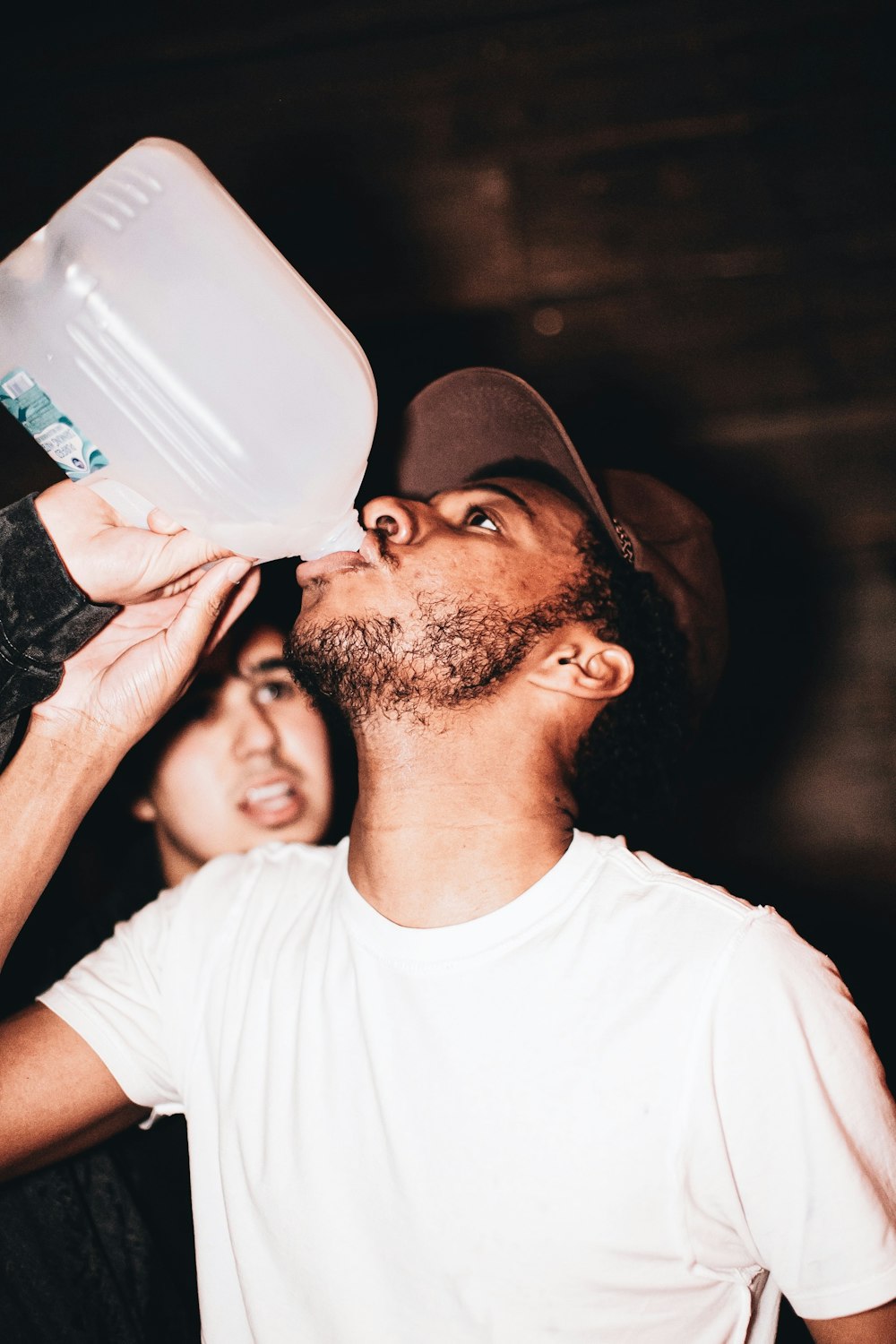 man in white crew neck t-shirt drinking from white ceramic mug