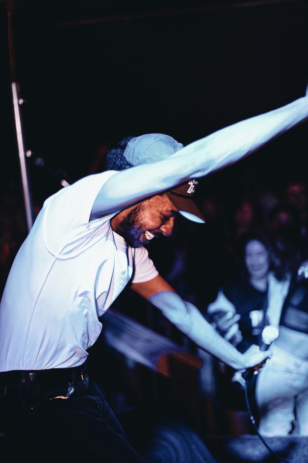 man in white shirt and black pants wearing white cowboy hat