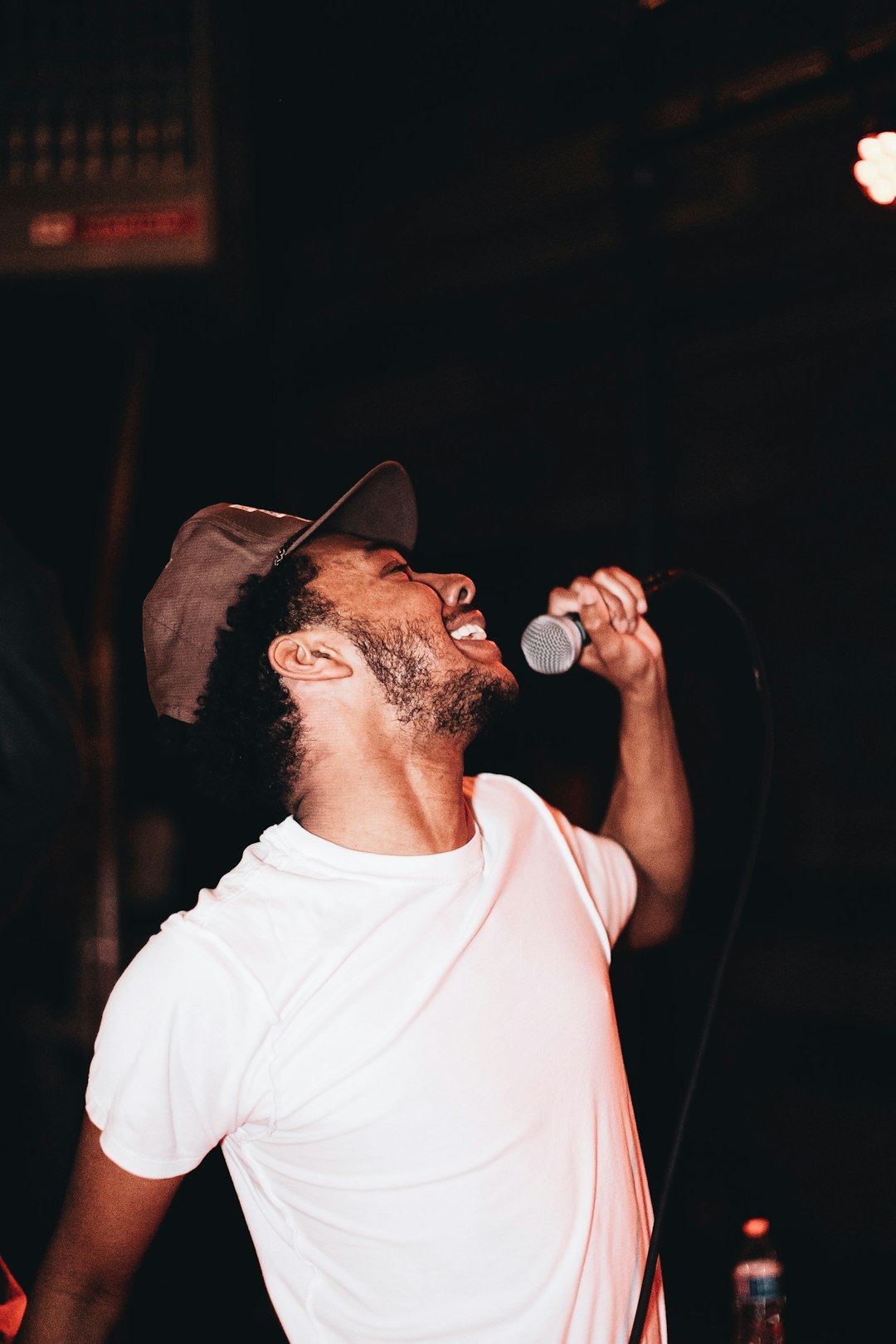 man in white crew neck t-shirt singing