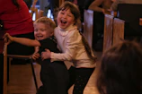 A cheerful child caregiver playing with a young child indoors
