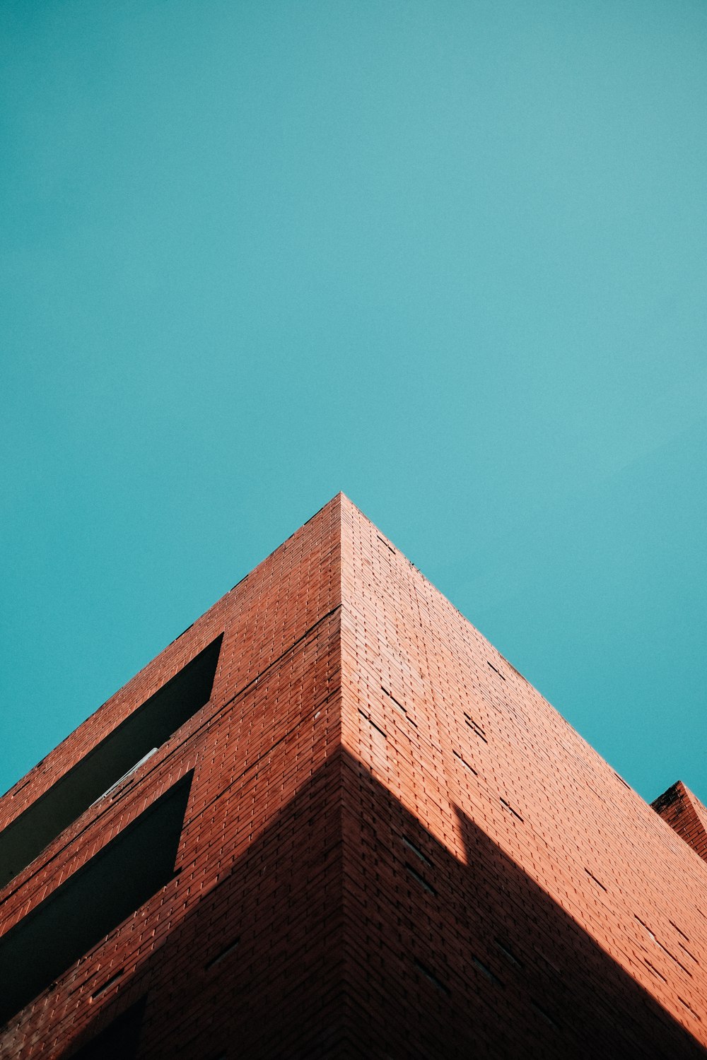 Edificio de hormigón marrón bajo el cielo azul durante el día