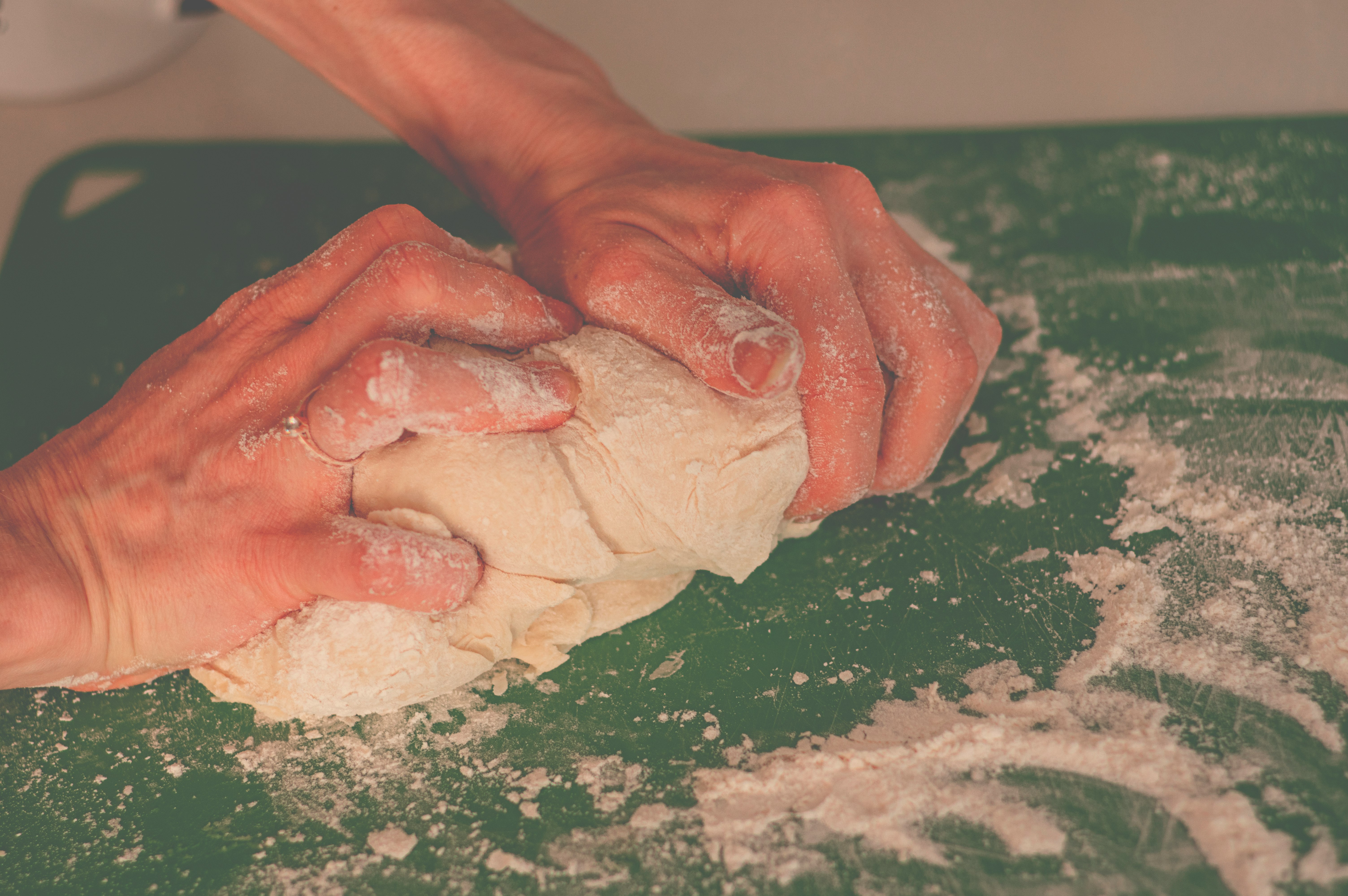 person holding dough on green table