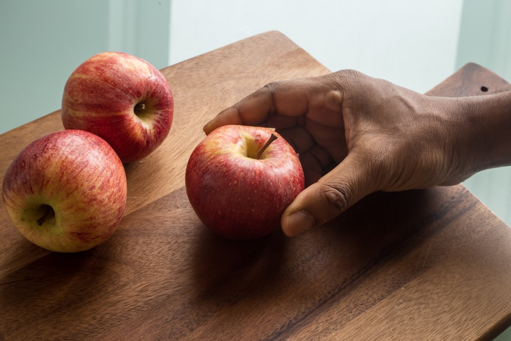 person holding red apple fruit