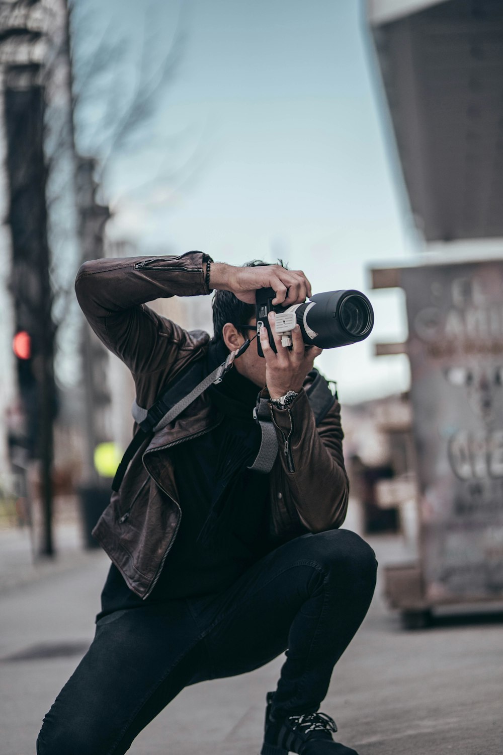 man in black jacket and black pants holding black camera