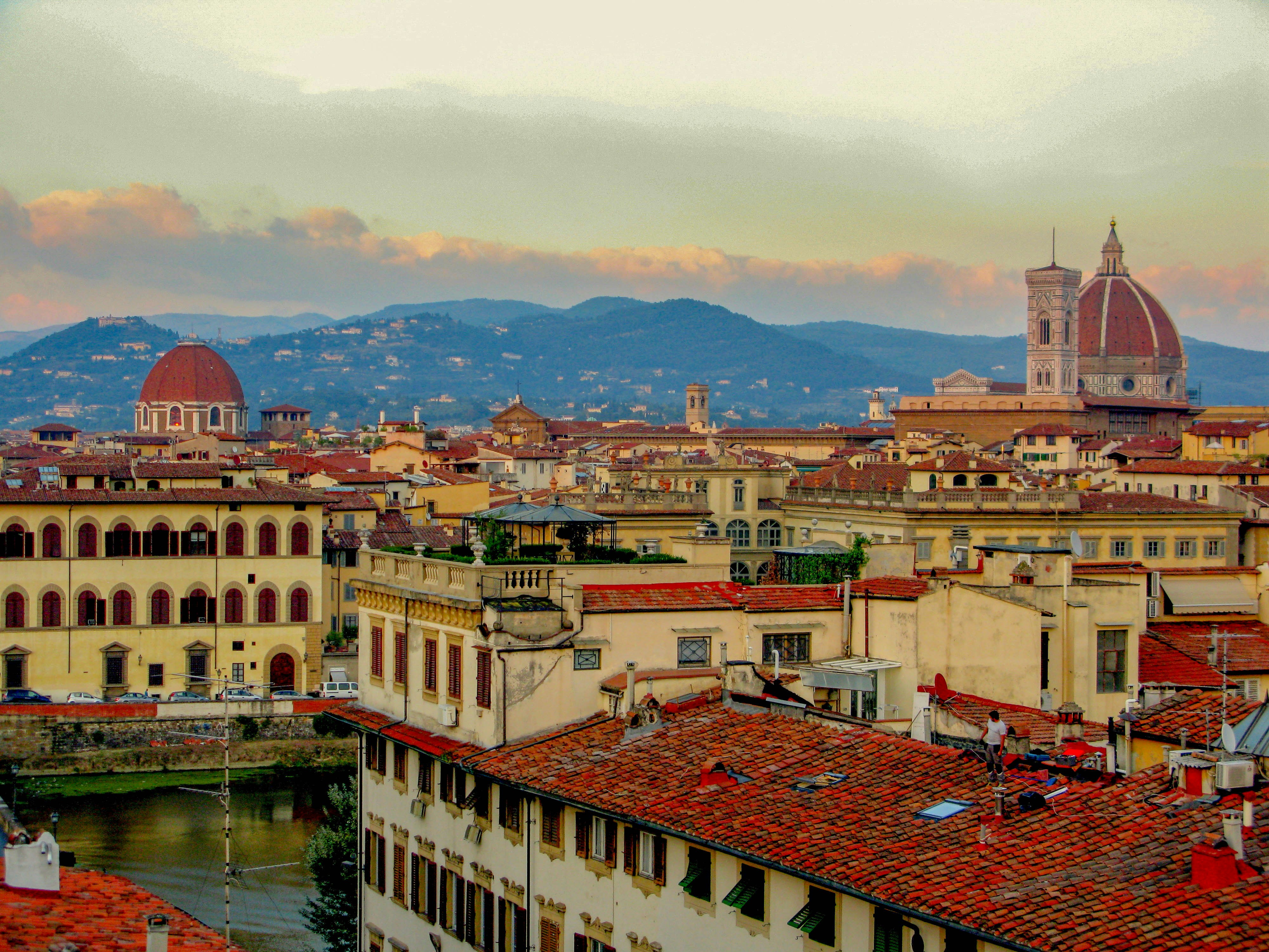 White and brown concrete building near river during daytime