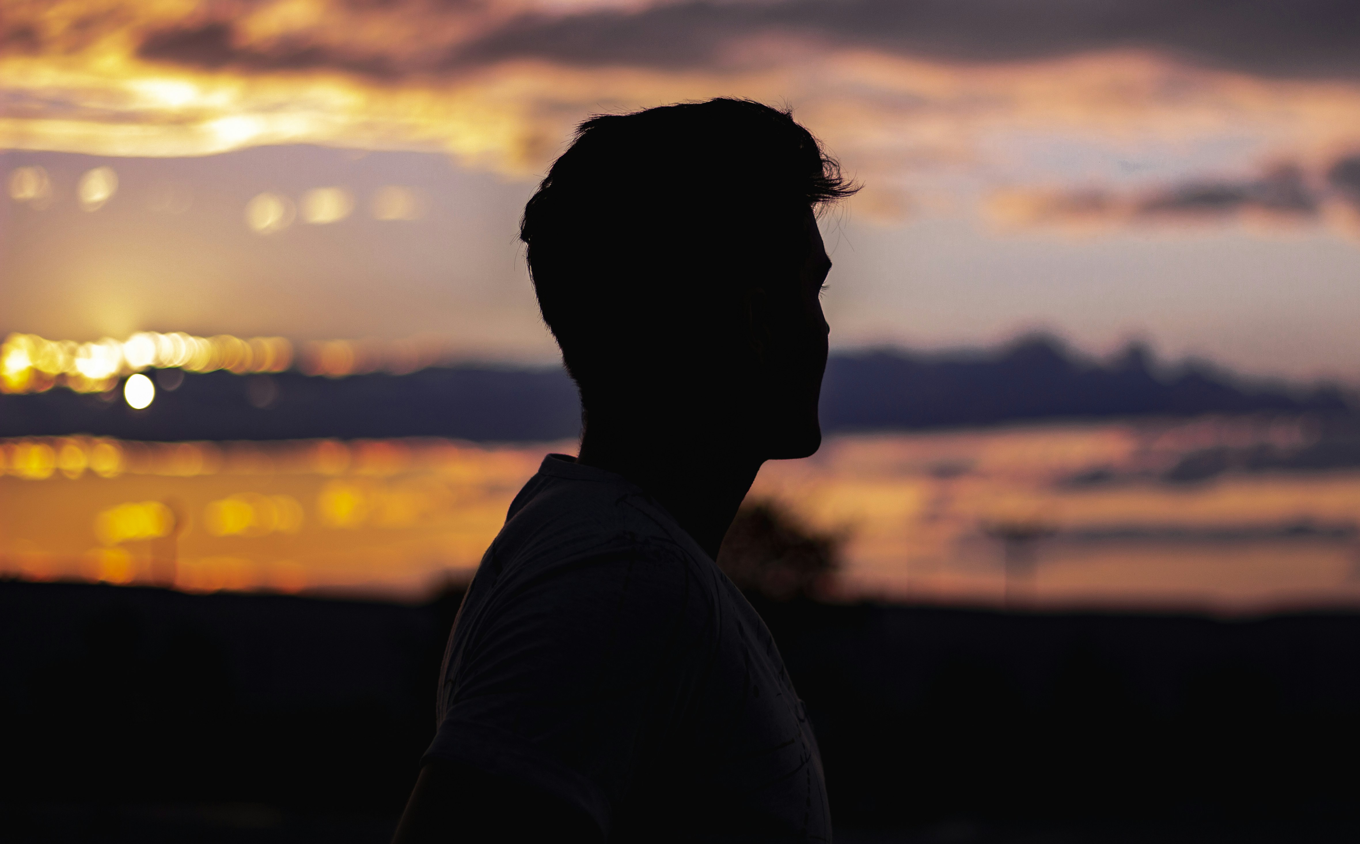 silhouette of man in white shirt during sunset