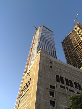 A modern office building under construction in Riyadh with clear blue sky.