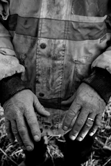 Close-up of Harry Berg’s worn hands holding a vintage union badge.