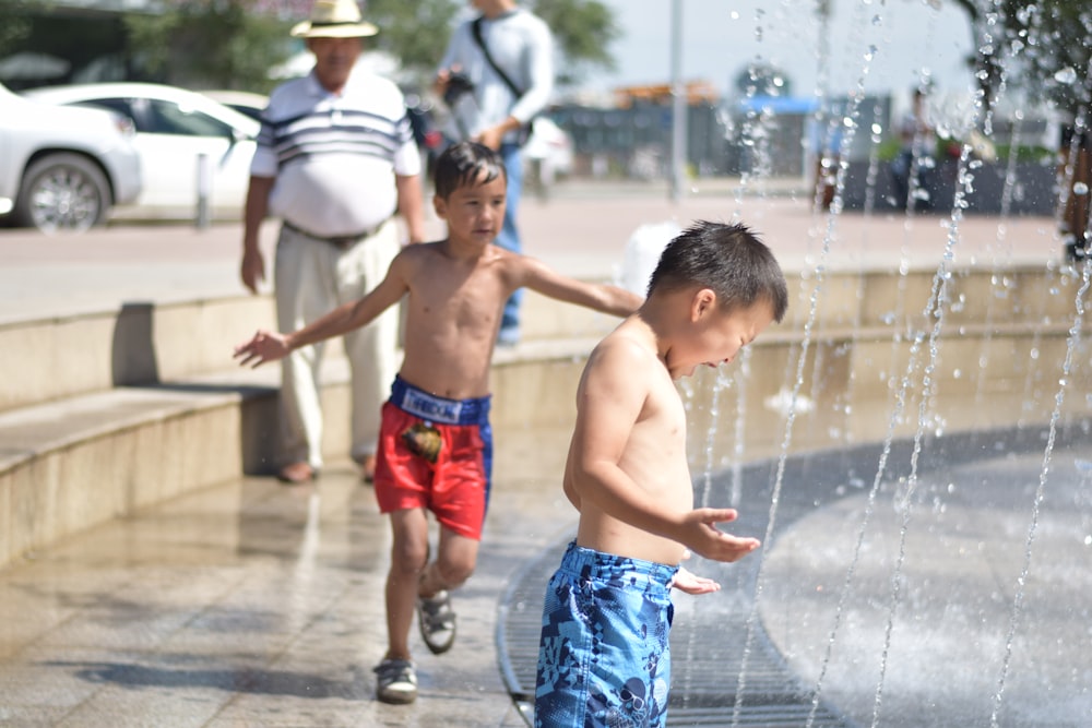boy in blue shorts playing with water