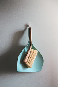Professional butter brush with fine pins on a wooden handle resting on a grooming table.