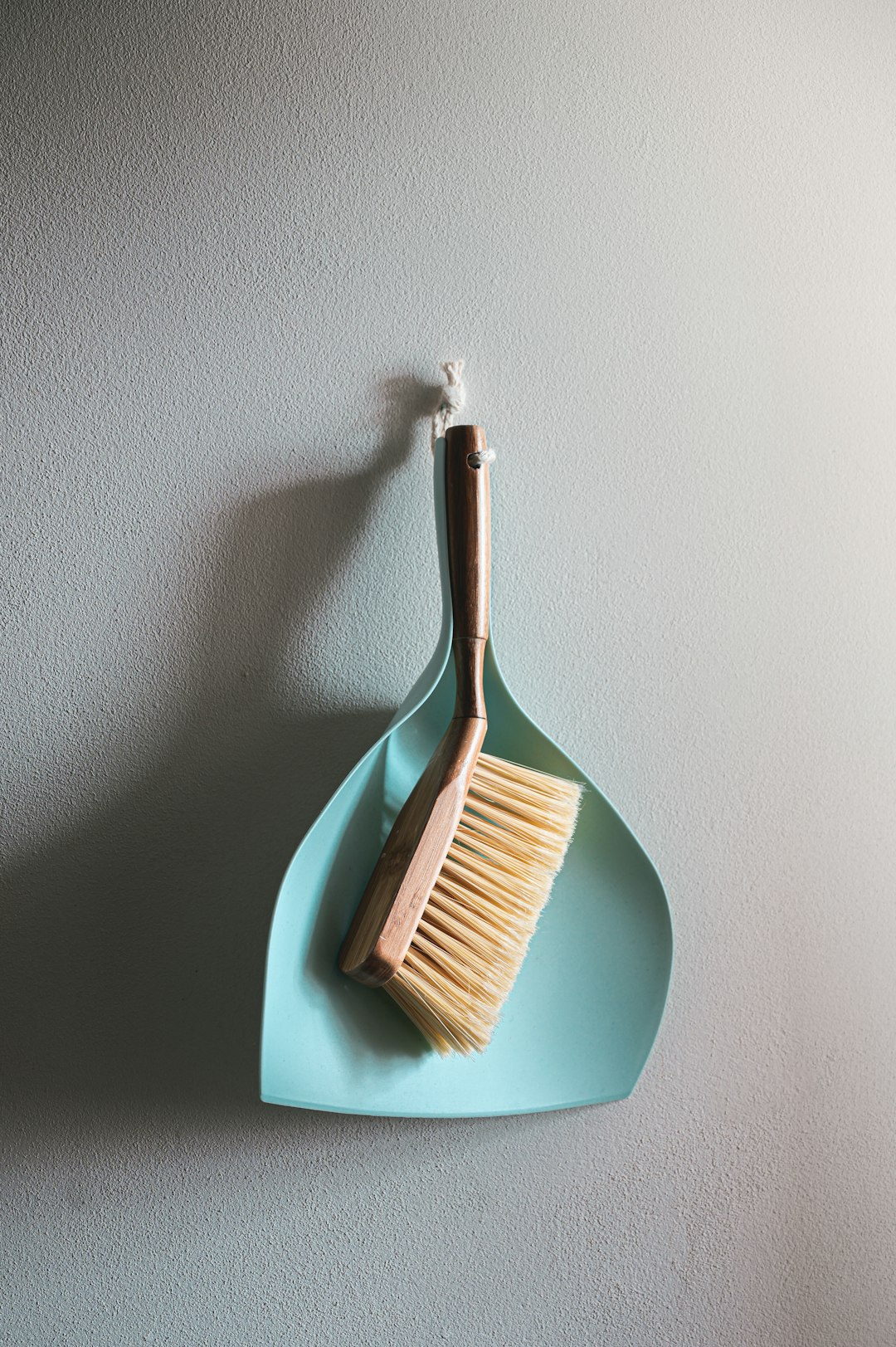  brown wooden brush on white wall broom