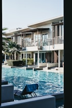 white concrete house near swimming pool during daytime