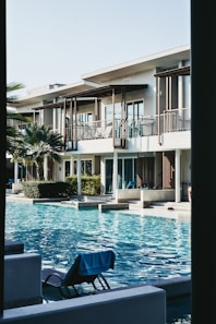 white concrete house near swimming pool during daytime