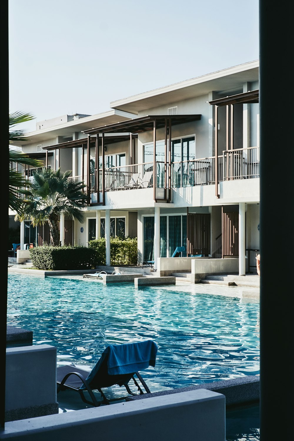 white concrete house near swimming pool during daytime