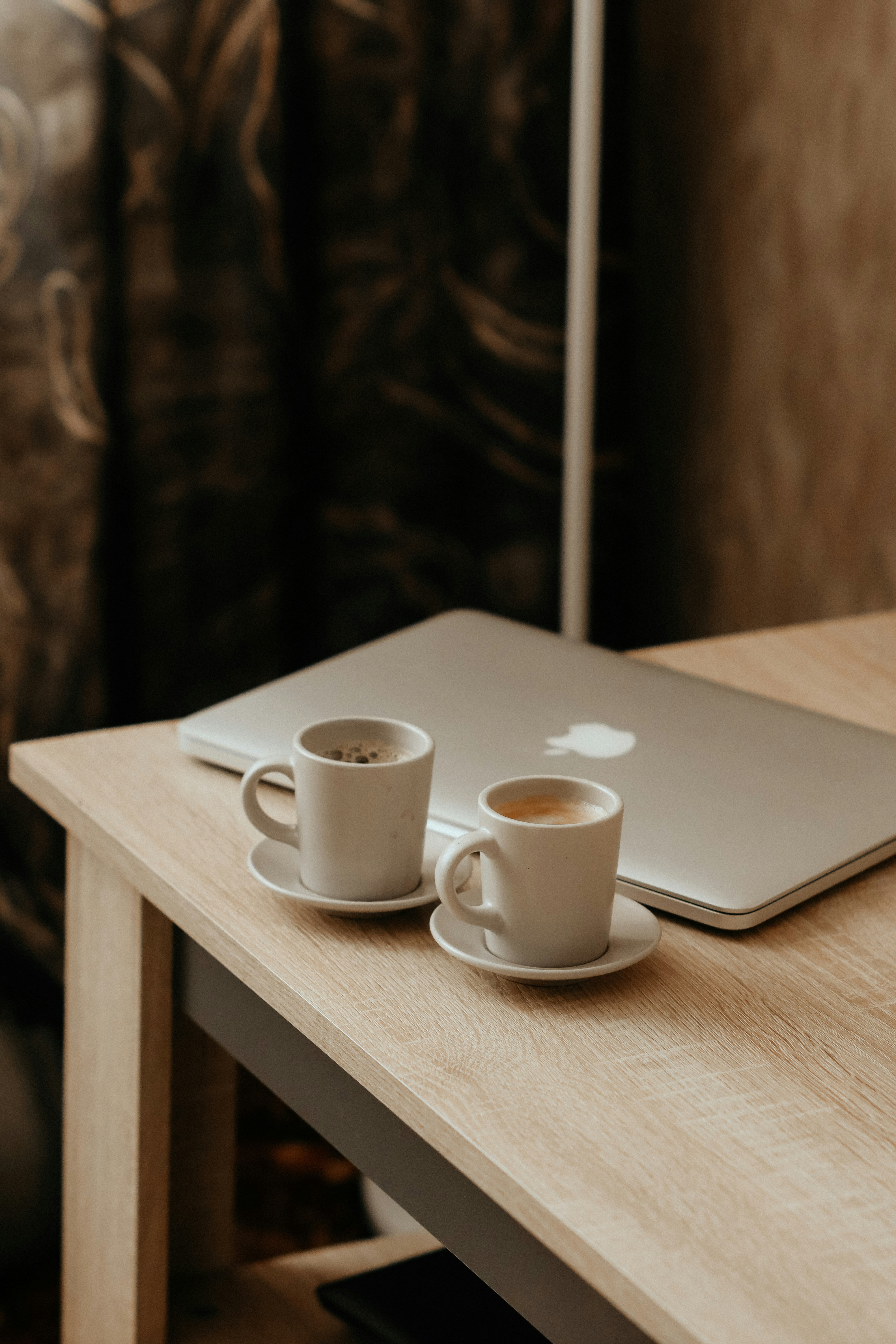 white ceramic mug on white ceramic saucer on brown wooden table