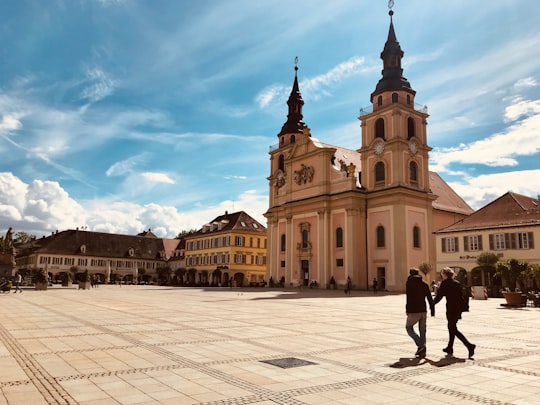 people walking near brown concrete building during daytime in Evangelische Stadtkirche Ludwigsburg Germany