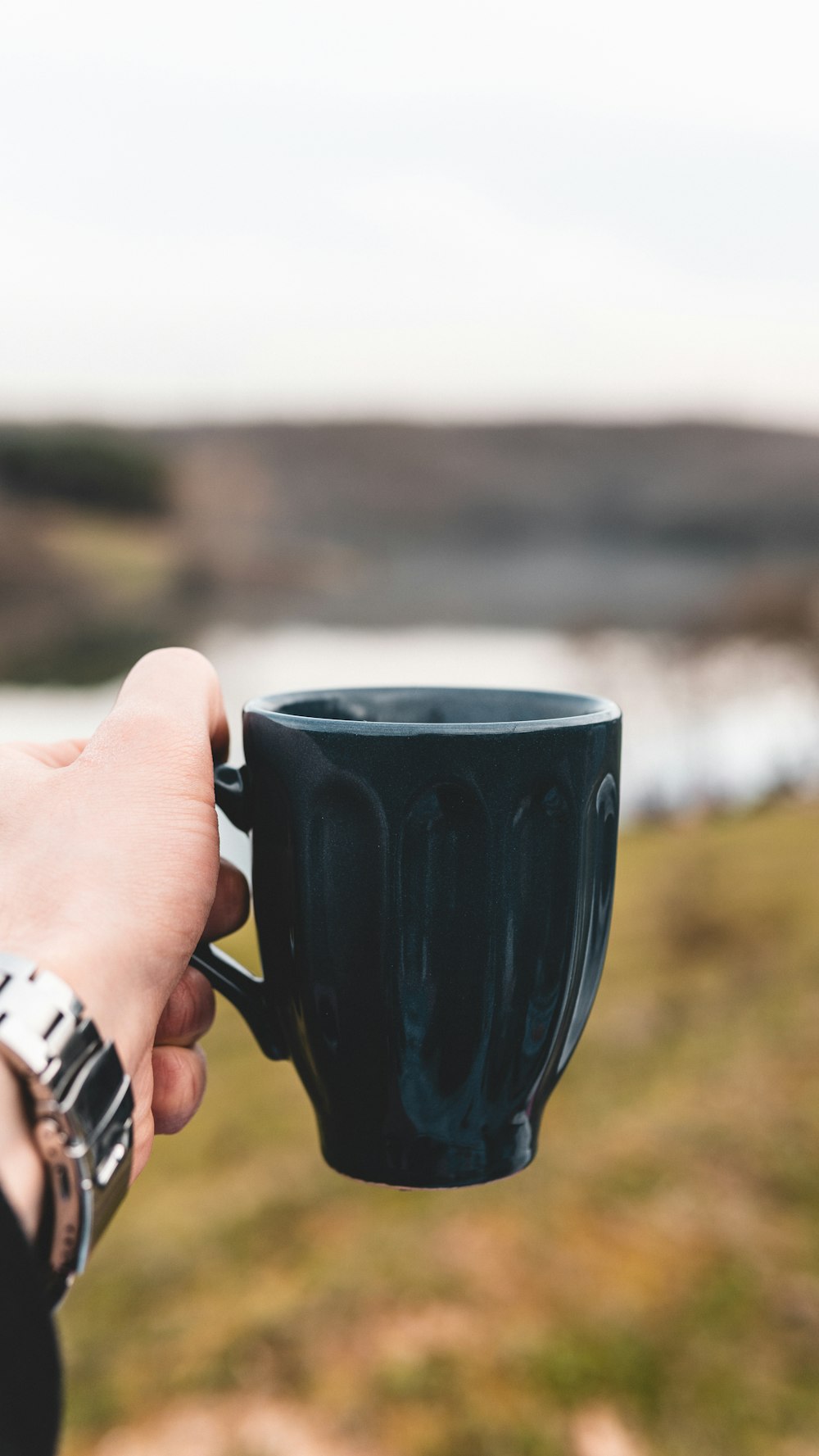 person holding blue ceramic mug