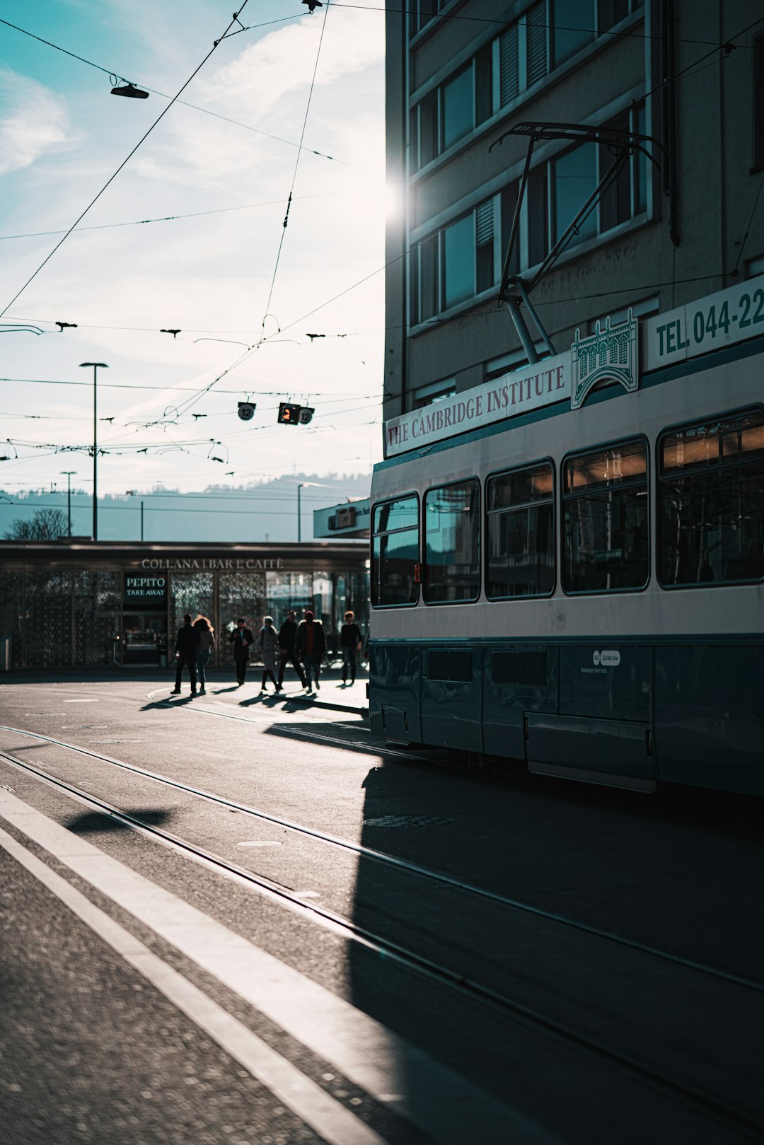 people walking on sidewalk near white and brown tram during daytime