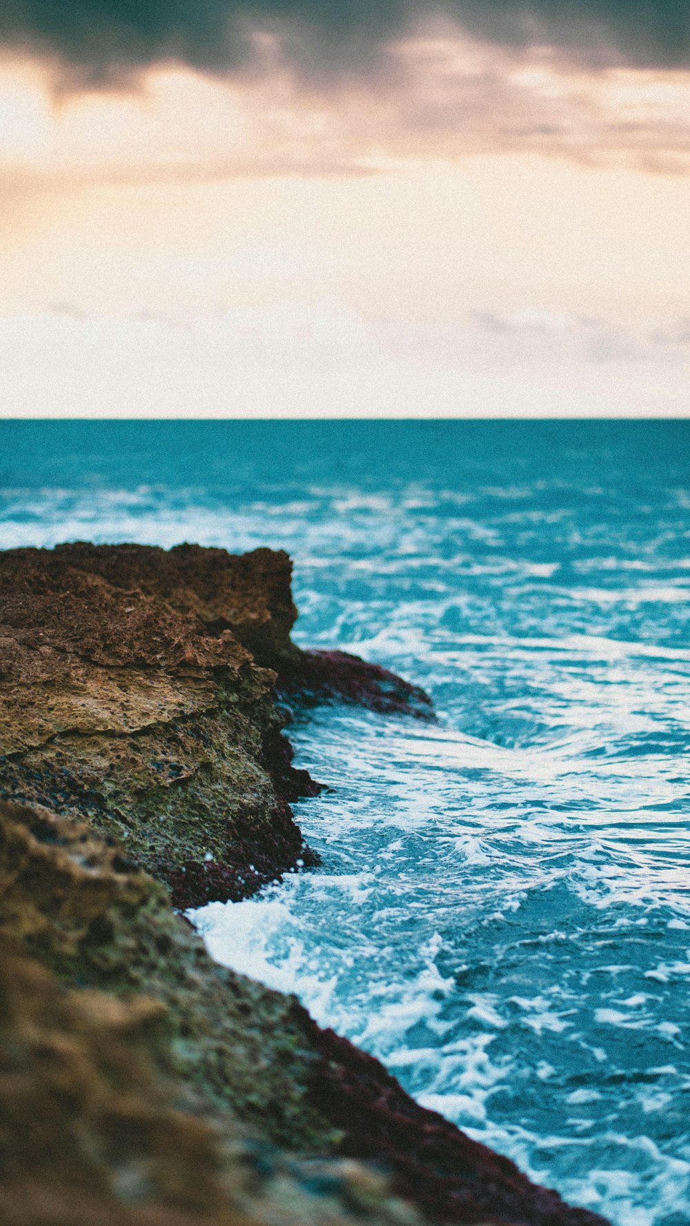 brown rock formation on sea water during daytime