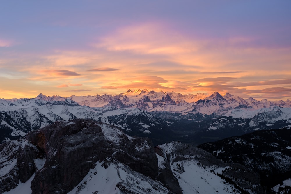 snow covered mountain during sunset