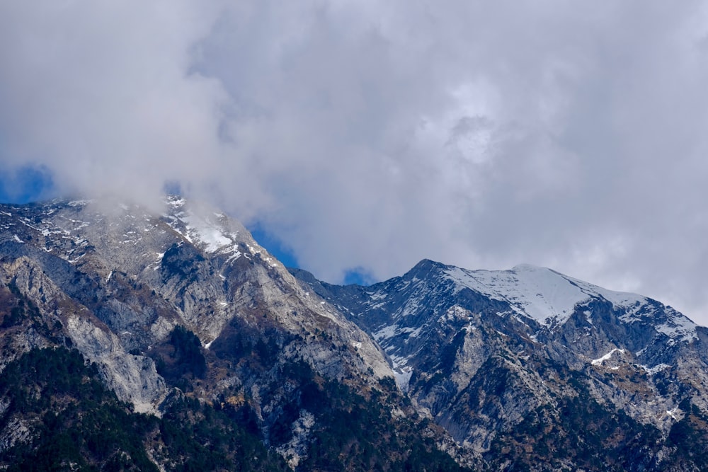 snow covered mountain under cloudy sky during daytime