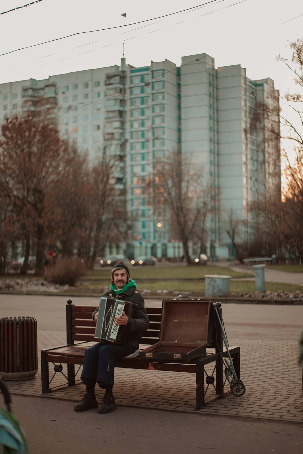 man in red and white jacket sitting on bench