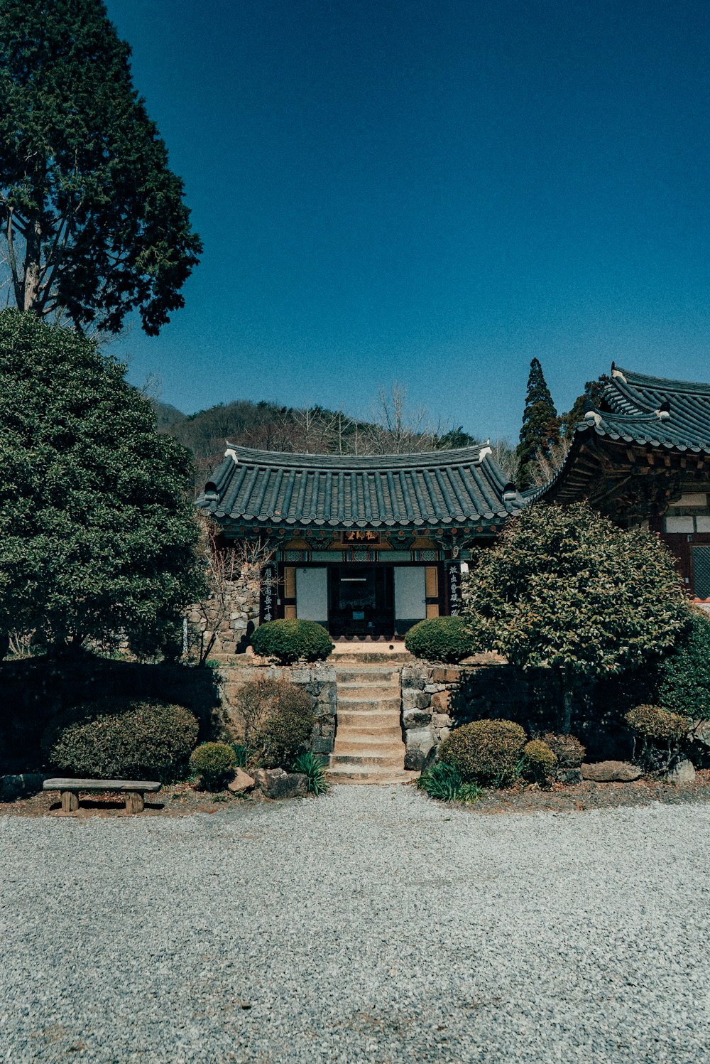 brown and white house surrounded by green trees under blue sky during daytime