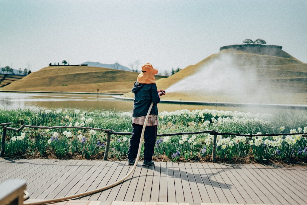 woman in black jacket standing on wooden dock during daytime