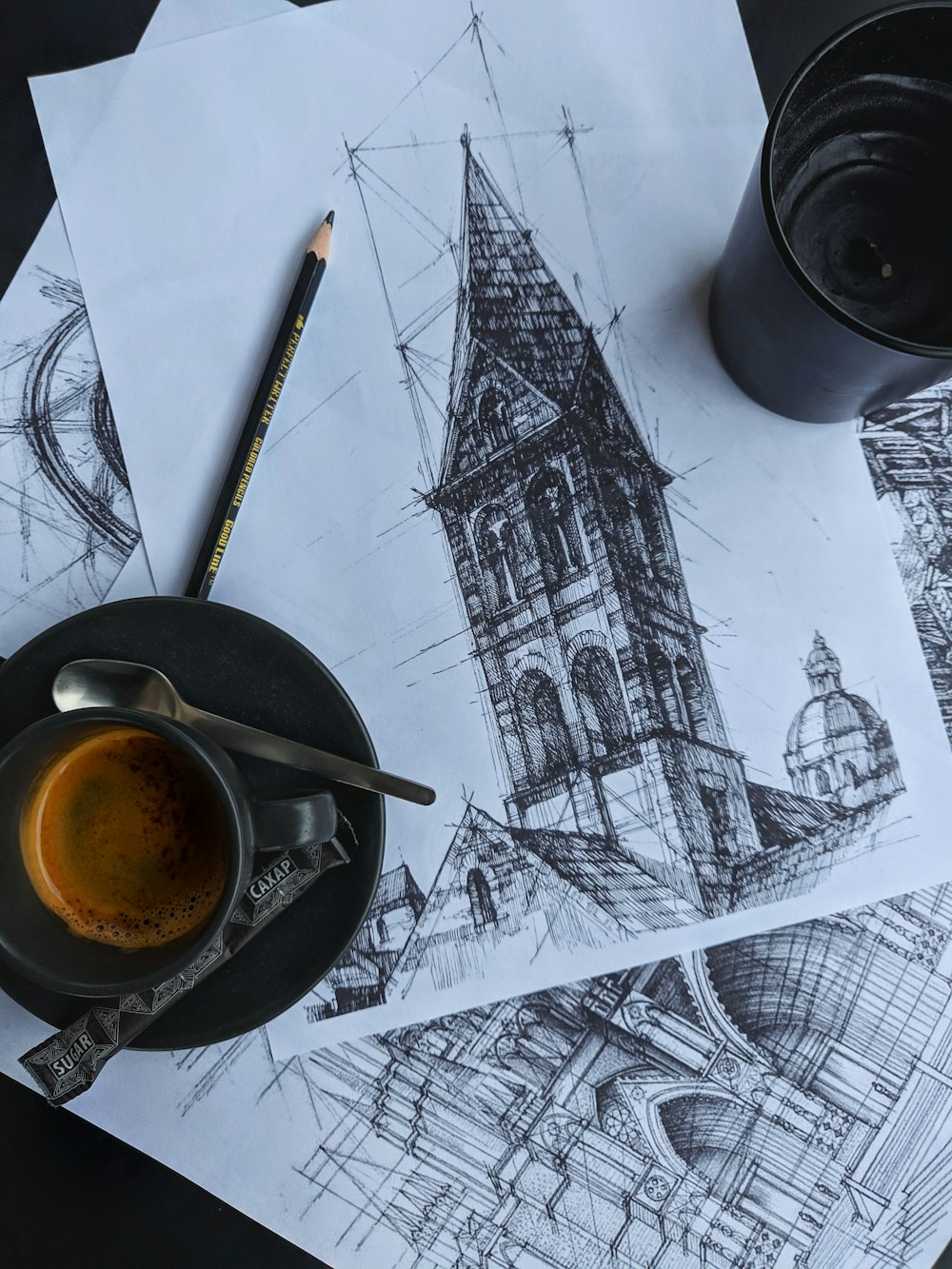 black ceramic mug with brown liquid on white and black table