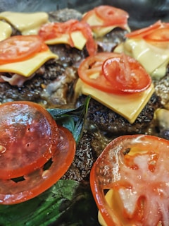 Close-up of a sizzling smash picaña burger on the grill with melted cheese and fresh toppings.