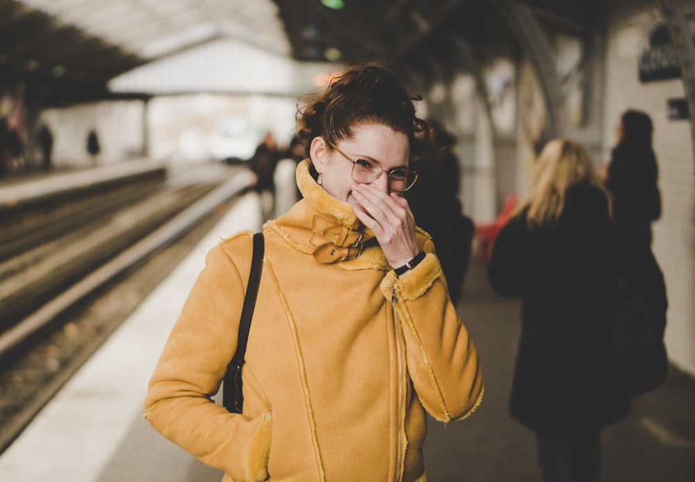 woman in brown coat wearing black framed eyeglasses